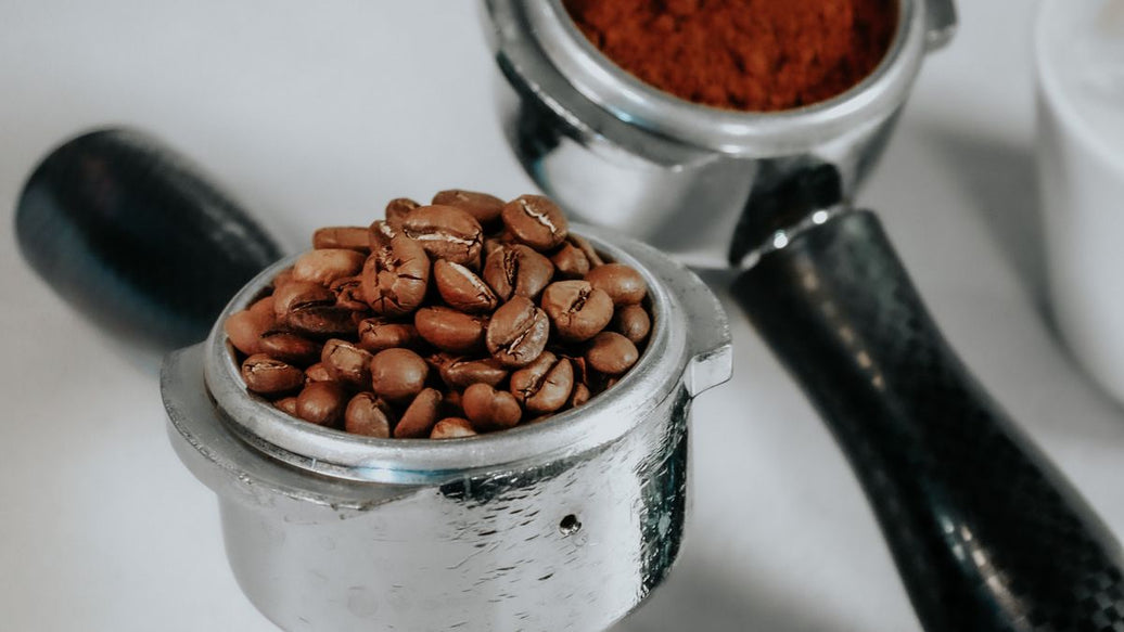Espresso için çekirdek ve öğütülmüş kahve dolu portafilter — espresso ve filtre kahve karşılaştırması